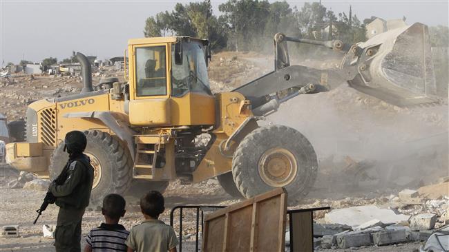 An Israeli bulldozer destroys the Palestinian homes and a community center in the southern West Bank village of Umm al-Kheir, near the Israeli settlement of Karmel, on August 24, 2016.
