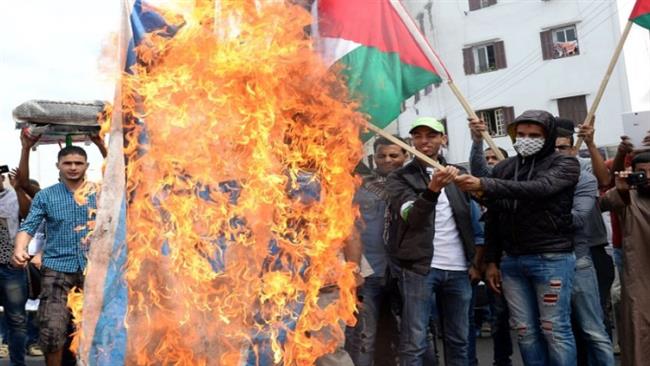 Moroccans burn an Israeli flag during a protest rally in the capital, Rabat, on November 9, 2016.