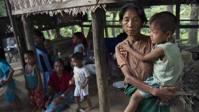 A displaced woman, member of the Myo ethnic group, carries her child at a Buddhist monastery in Maungdaw town, located in Rakhine State, Myanmar, on October 15, 2016. (Photo by AFP)