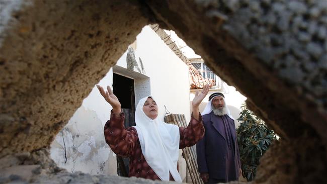 A picture taken on November 10, 2016 in Yatta, south of the occupied West Bank city of al-Khalil (Hebron), shows the mother (L) of Palestinian Younes Zein, reacting outside her son