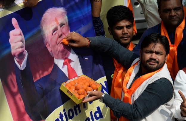 Amember of Indian anti Muslim group offer sweets to a poster of President-elect Donald Trump