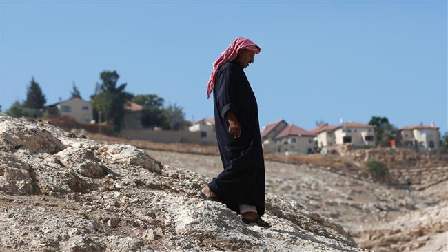 A Palestinian Bedouin walks past the Israeli settlement of Kedar in the Bedouin village of Wadi Abu Hindi, near the town of al-Azariya in the occupied West Bank, October 10, 2016. (Photo by AFP)