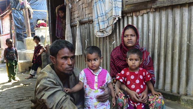 Deen Mohammad (L) and his wife Roshida, whose two elder sons were taken by the Myanmar military, pose for a photograph with their younger children after their escape from Myanmar, in a refugee camp in Teknaf in the southern Cox