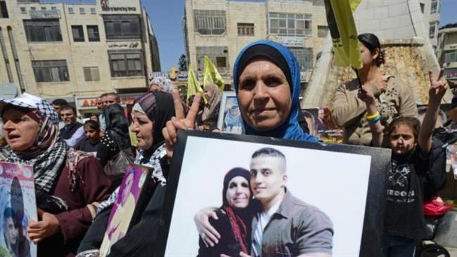 Palestinians hold photos of family members held in Israeli prisoners during a protest on Palestinian Prisoner Day in Ramallah, Israel-occupied West Bank.