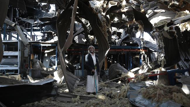 In this September 22, 2016 photo, a Yemeni man stands amid the rubble of a factory hit by Saudi airstrikes, in Sana’a, Yemen