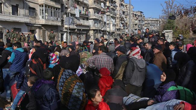 Syrian residents fleeing the violence gather at a checkpoint, manned by government forces, in the Maysalun neighborhood of Aleppo on December 8, 2016. (Photo by AFP)
