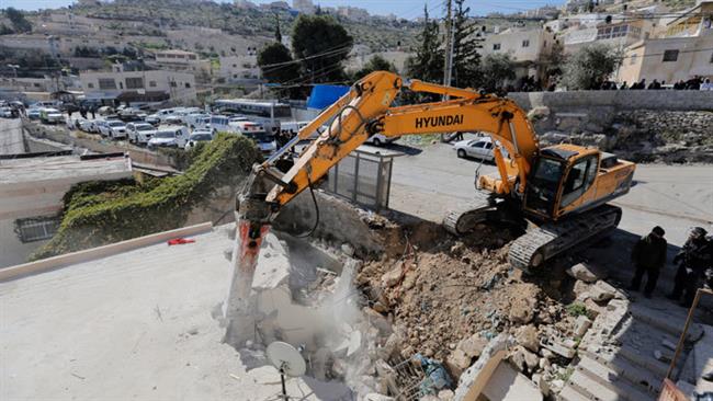 In this file photo, an Israeli bulldozer demolishes a Palestinian house in the predominantly Arab neighborhood of Jabel Mukaber in southern East Jerusalem al-Quds. (Photo by Reuters)