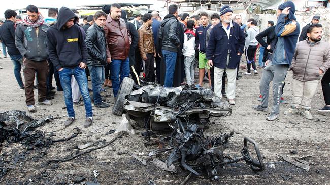 Iraqis inspect a charred vehicle on the site of a terrorist bomb attack in Sadr City in the north of the capital, Baghdad, on January 2, 2017. (Photo by AFP)
