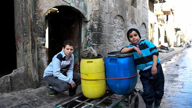 This handout picture provided by UNHCR on January 4, 2017 shows Syrian boys beside a cart they use to carry water back to their home in an east Aleppo neighborhood. (Photo by Reuters)
