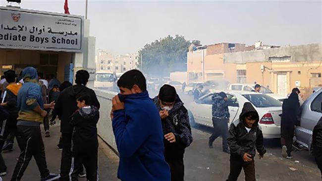 Bahraini schoolboys react after regime forces fire tear gas canisters outside their school on Sitra Island, eastern Bahrain, on January 11, 2017.