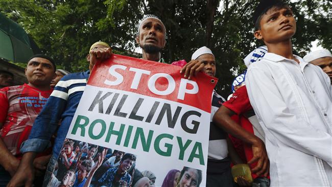 An ethnic Rohingya Muslim holds a banner during a protest after Friday prayers outside Myanmar