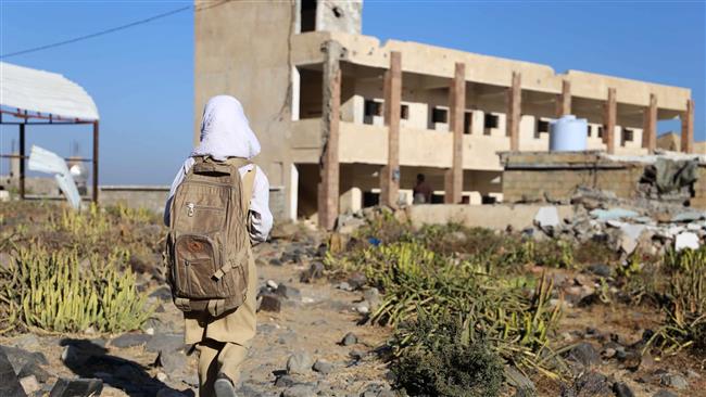 A Yemeni girl walks past a damaged building as she arrives at her school that was hit by a Saudi airstrike, December 27, 2016. (Photo by AFP)