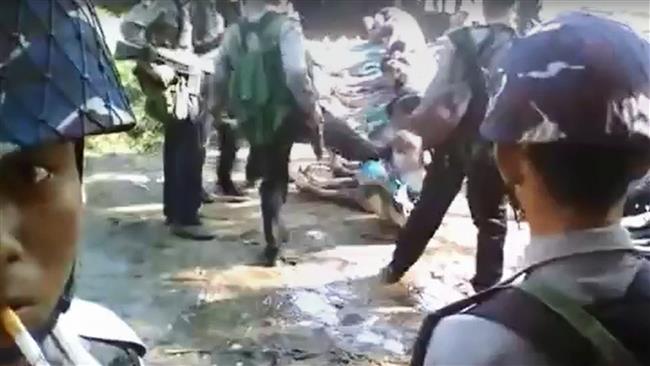 This screen grab taken on January 4, 2017, from a video on social media shows a policeman (back C) kicking a Rohingya minority villager seated on the ground with others, in the village of Kotankauk, November 5, 2016. (Photo by AFP)