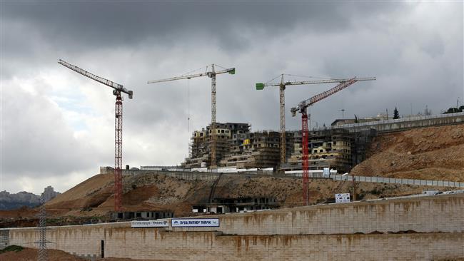 This file photo, taken on January 27, 2016, shows cranes at a construction site in the Israeli settlement of Ramot, illegally built in a suburb of East Jerusalem al-Quds. (By AFP)