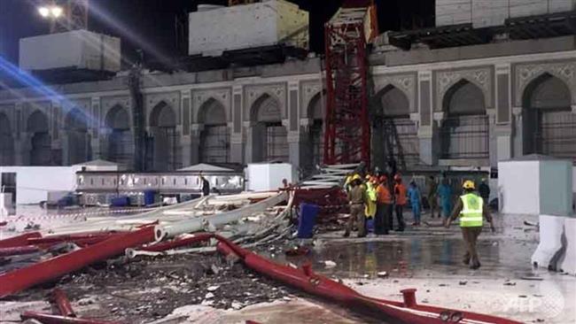 Saudi emergency teams stand next to a construction crane after it crashed into Mecca