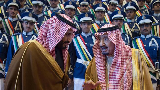 Saudi King Salman bin Abdulaziz (R) is seen chatting with Deputy Crown Prince Mohammed bin Salman during a military ceremony in Riyadh