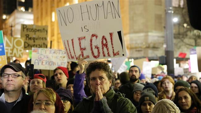 People react as speakers denounce the recent actions of US President Donald Trump at a rally for immigrants and refugees in Seattle, Washington on January 29, 2017. (Photo by AFP)