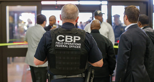 A Customs and Border Protection (CBP) federal officer watches from inside the terminal during a protest at Hartsfield-Jackson Atlanta International Airport