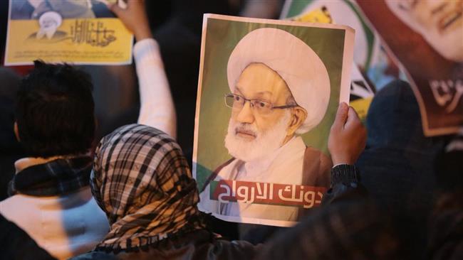 Protesters hold posters depicting Shia cleric Sheikh Isa Qassim in Diraz, Bahrain