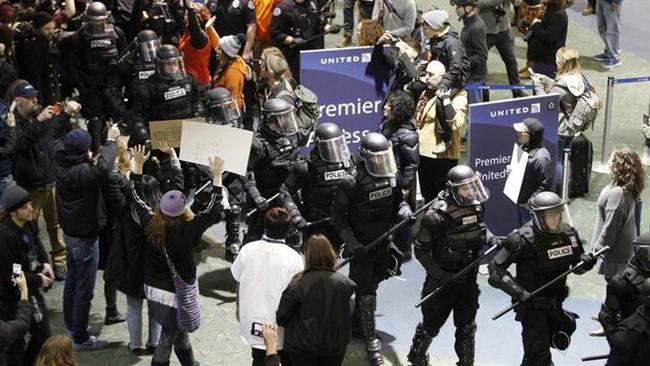 Riot police arrive as activists gather at Portland International Airport to protest against President Donald Trump