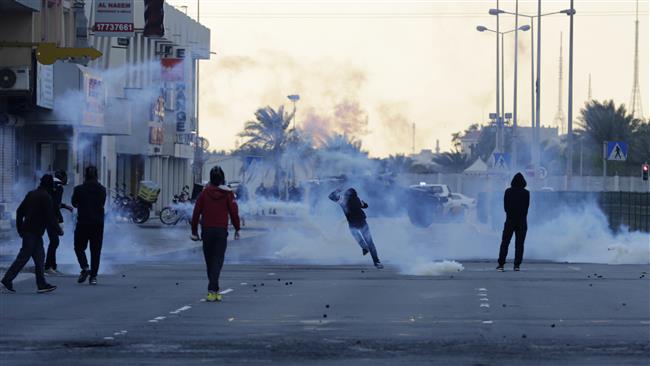 Bahraini anti-regime protesters clash with police firing tear gas in Sitra, Bahrain