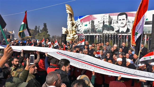 Syrians wave the national flag during a gathering in Aleppo