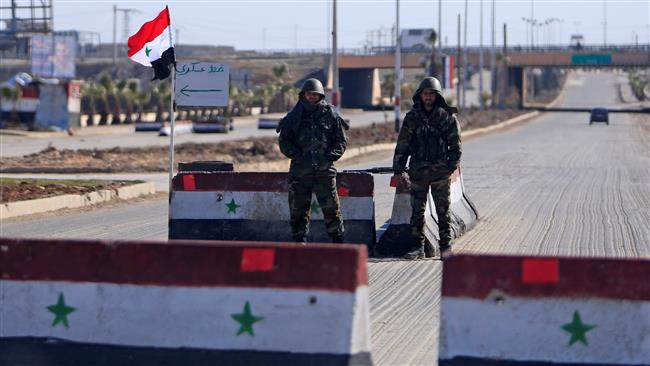 Syrian army soldiers man a checkpoint along a road in Aleppo