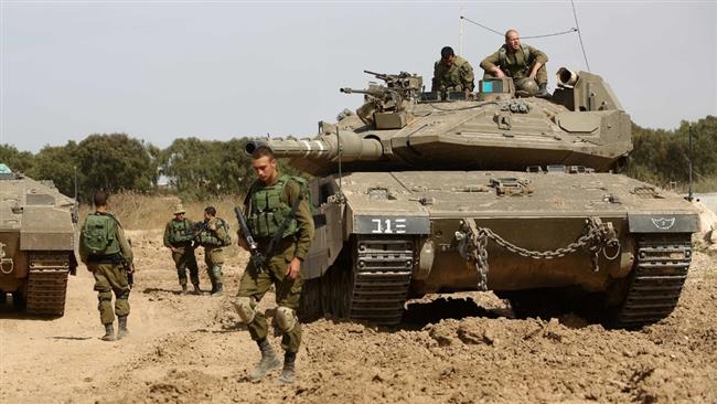 Israeli soldiers stand guard with their tank along the border between the occupied Palestinian territories and the Gaza Strip on May 4, 2016. (Photo by AFP)

