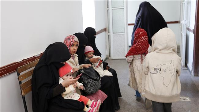 Yemeni infants suffering from malnutrition wait for treatment in the hallway of a medical center in Bani Hawat, on the outskirts of the Yemeni capital Sana