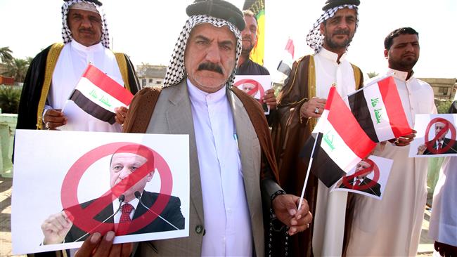Iraqi tribesmen hold national flags and posters bearing a portrait of Turkish President Recep Tayyip Erdogan crossed out during a protest against the continued presence of Turkish troops in northern Iraq, in the southern city of Basra on October 16, 2016. (Photo by AFP)