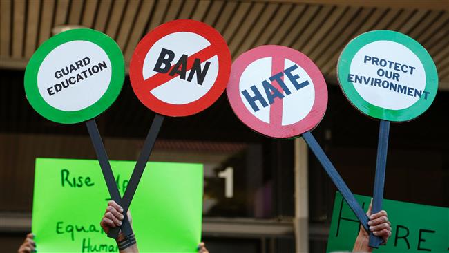 Protesters hold up signs during an anti-Trump rally in Miami, Florida