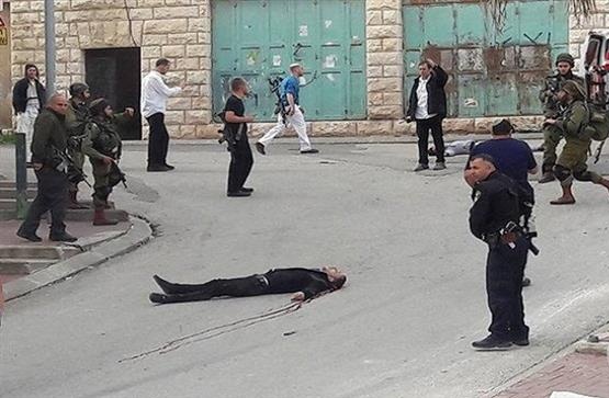 Palestinian Abdel Fattah al-Sharif lies on the ground following a fatal shooting in the occupied southern West Bank city of al-Khalil (Hebron) on March 24, 2016.