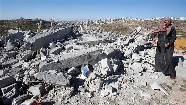 This file photo shows a Palestinian woman inspecting the ruins of her home destroyed by Israeli soldiers in East Jerusalem al-Quds.