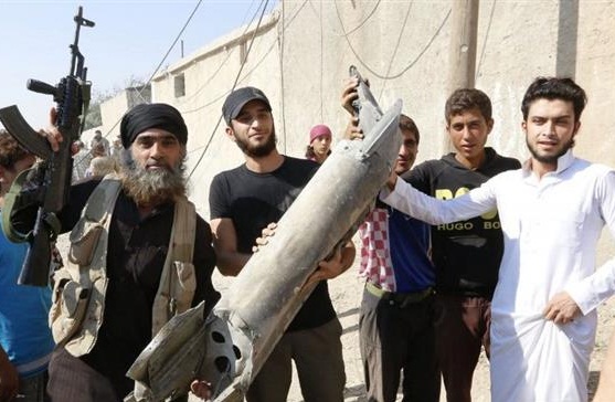 A Daesh militant stands next to residents in Raqqah in northeast Syria