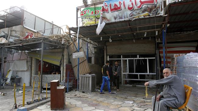 An Iraqi man sits outside a shop on March 21, 2017, the morning after a car bomb attack, in the business district of Hay al-Amel, in the west of the capital, Baghdad. (File photo by AFP)
