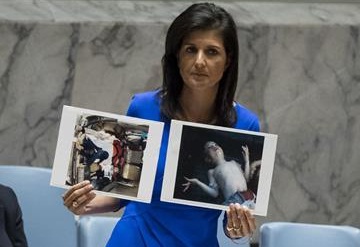 US Ambassador to the United Nations Nikki Haley holds up photos of victims of a chemical attack in Syria during a meeting of the United Nations Security Council at UN headquarters, April 5, 2017 in New York City.