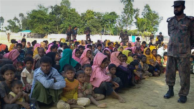 Rohingya Muslims from Myanmar, who tried to cross the Naf river into Bangladesh to escape sectarian violence, are kept under watch by Bangladeshi security officials in Teknaf on December 25, 2016. (Photo by AFP)
