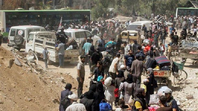 Syrian citizens gather with their belonging as they prepare to evacuate from Darayya