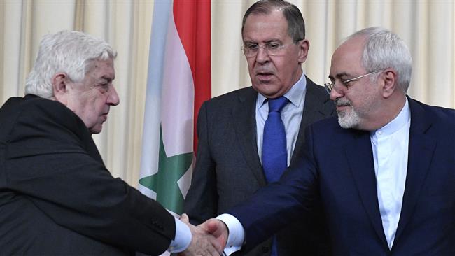 Iranian Foreign Minister Mohammad Javad Zarif (R) shakes hands with his Syrian counterpart Minister Walid Muallem (L) as Russian Foreign Minister Sergei Lavrov