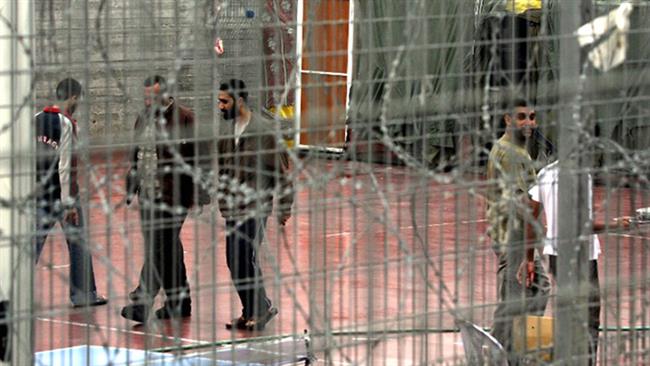 Palestinian prisoners walk at the yard of the Israeli prison