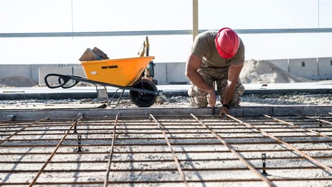An airman ties together reinforcing bars to hold and strengthen a concrete foundation for a new structure being built at an undisclosed location in Southwest Asia, March 21, 2017. (Photo via Stars and Stripes)
