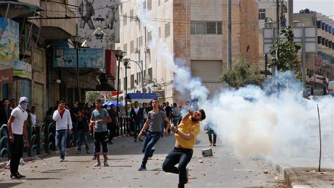 Palestinian protesters supporting hunger strikers in Israeli jails throw stones in the occupied West Bank city of al-Khalil on April 27, 2017, during clashes with Israeli forces. (Photo by AFP)
