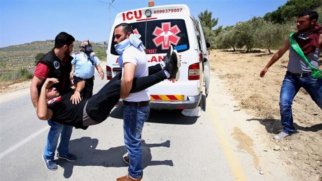 A young Palestinian man is carried by Palestinian medics after being shot and injured in Arrub refugee camp in the occupied West Bank on May 3, 2017. (Photo by Safa news agency)
