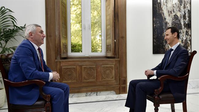 Syrian President Bashar al-Assad (R) speaks during an exclusive interview with Belarus