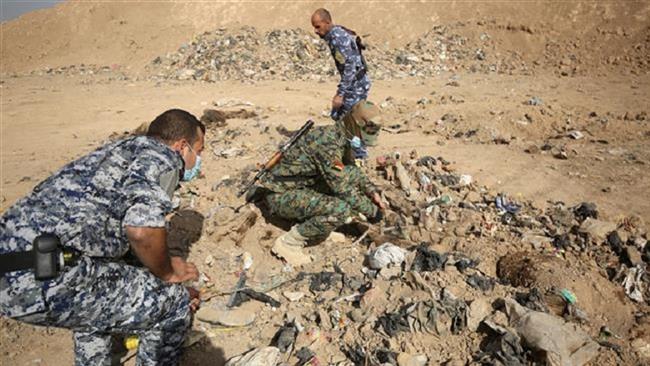 Iraqi troops check a mass grave discovered in Hammam al-Alil town on November 7, 2016, after it was recaptured from the Daesh Takfiri terrorist group. (Photo by AFP)
