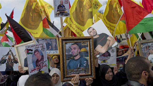 Protesters carry the pictures of hunger-striking Palestinian prisoners, in the West Bank city of Ramallah, May 3, 2017. (Photo by AP)
