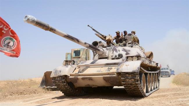 Popular Mobilization Units (PMU) ride on a tank during a battle with Daesh, at Um Jaris village on the Iraqi border with Syria, on May 29, 2017. (Photo by Reuters)
