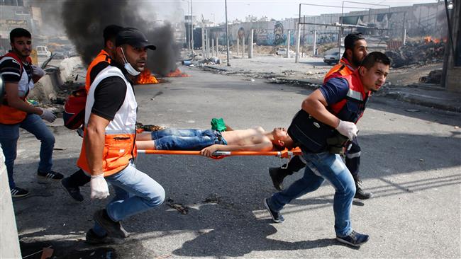 Palestinian medics evacuate a wounded protester during clashes with Israeli forces at the Qalandiya checkpoint in the occupied West Bank on May 22, 2017. (Photo by AFP)
