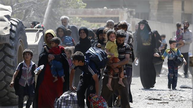 Iraqis, among them children, leave Zanjili neighborhood in west Mosul on June 3, 2017, during the ongoing offensive by security forces to retake the city from Daesh terrorists. (Photo by AFP)
