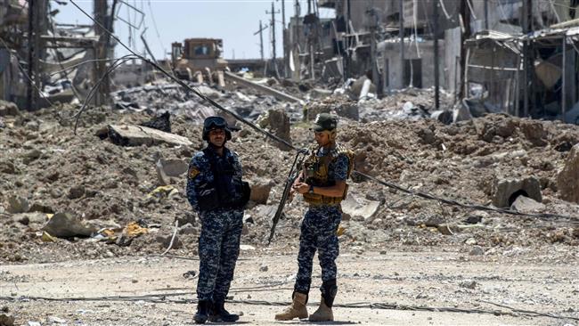 Iraqi government forces stand at attention in western Mosul